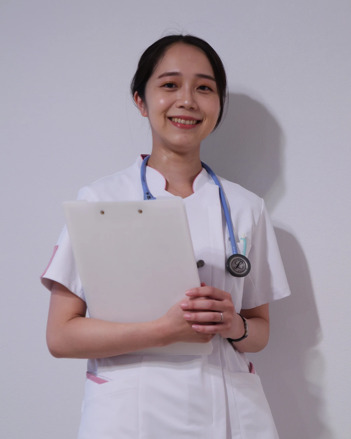 クリップボードを手にやさしく微笑む訪問看護師